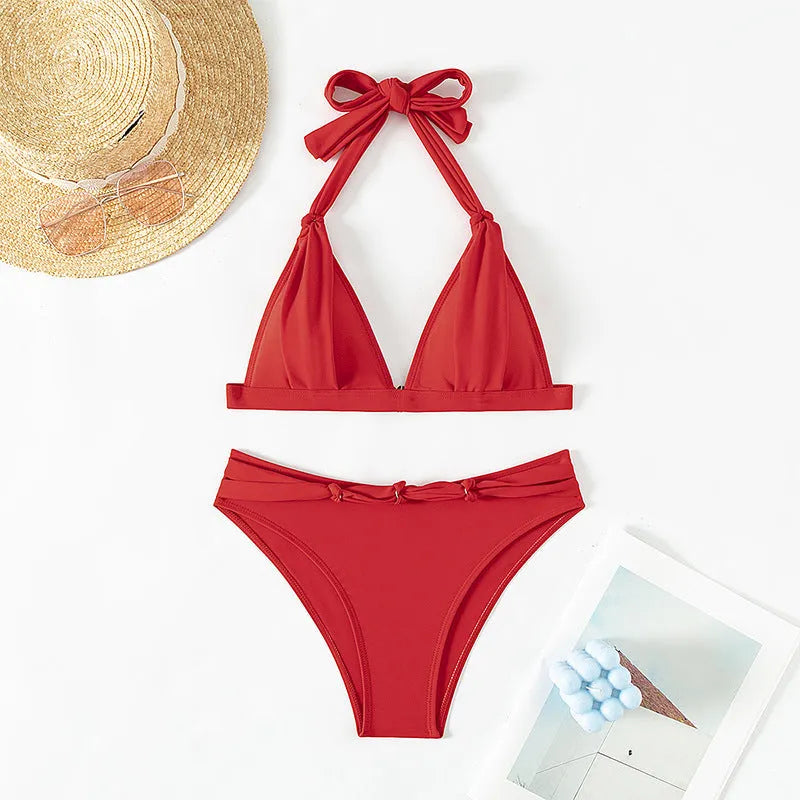 Red women's lace-up halterneck bikini top and matching shorts on a plain background.