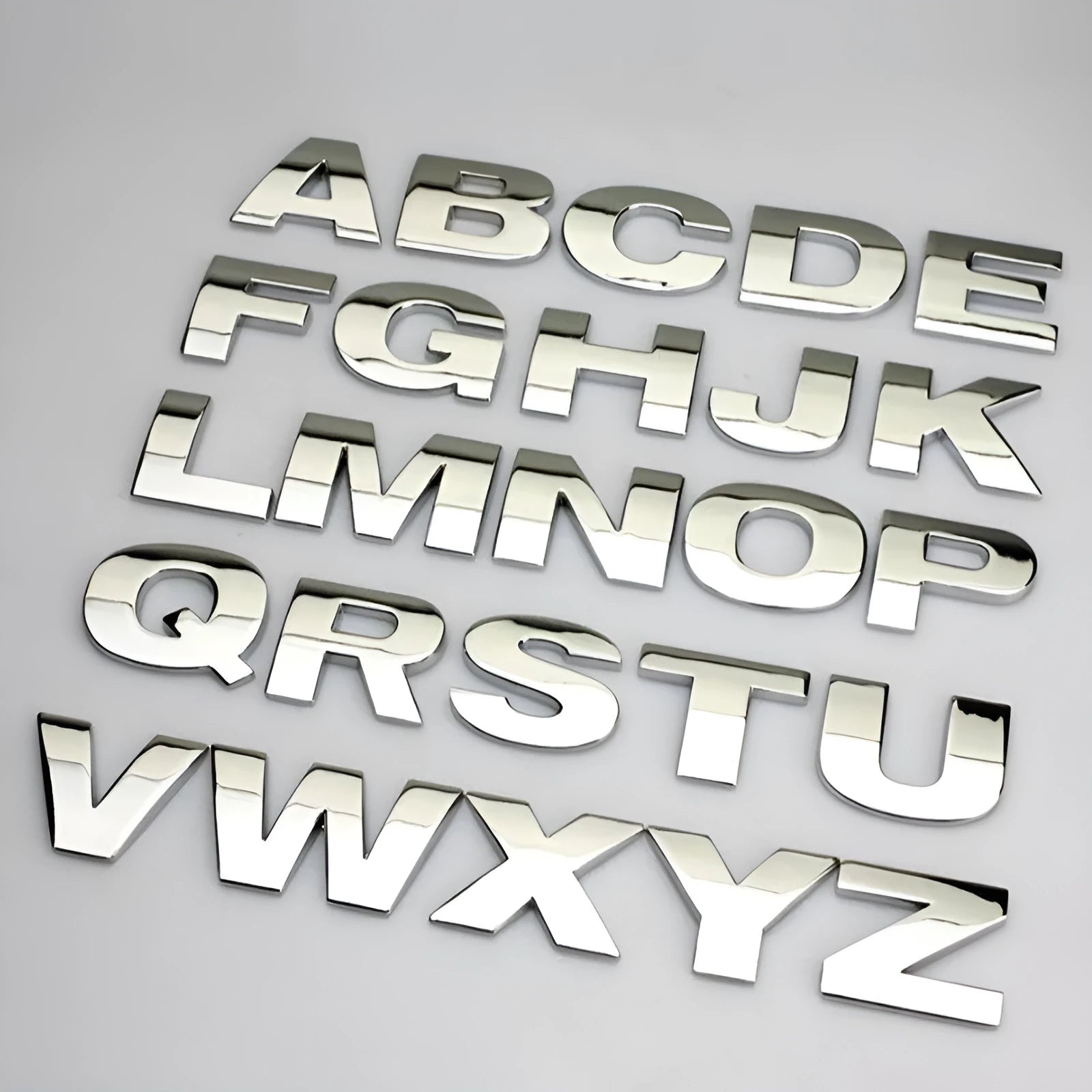 3D metal zinc alloy car letter sticker showing raised silver letter on clear adhesive backing.