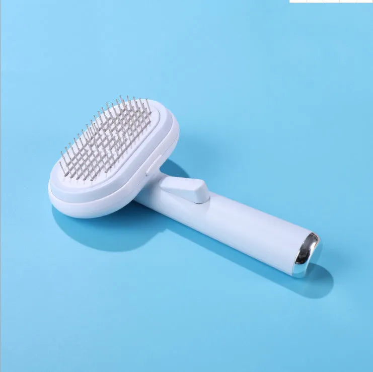 Blue and pink pet hair removal brush with steel needles on a light background