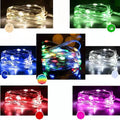 Copper wire battery-operated string lights wrapped around branch with multiple LED colours illuminated