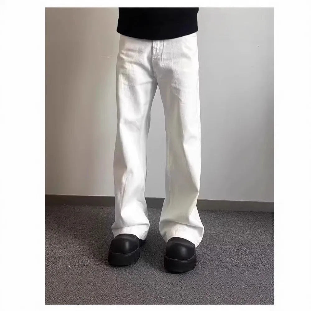 Man wearing loose straight-leg white denim jeans with a wide leg opening.