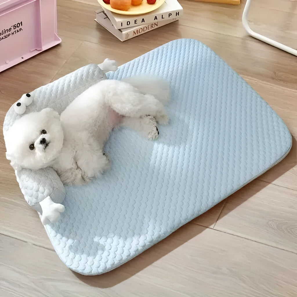Blue pet cooling mat with big-eyed monster design on a wooden floor, shown in large (L) size.