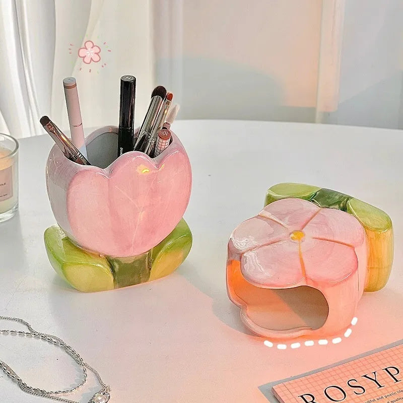 Ceramic pen holder box with floral pattern and lid on a wooden desk.