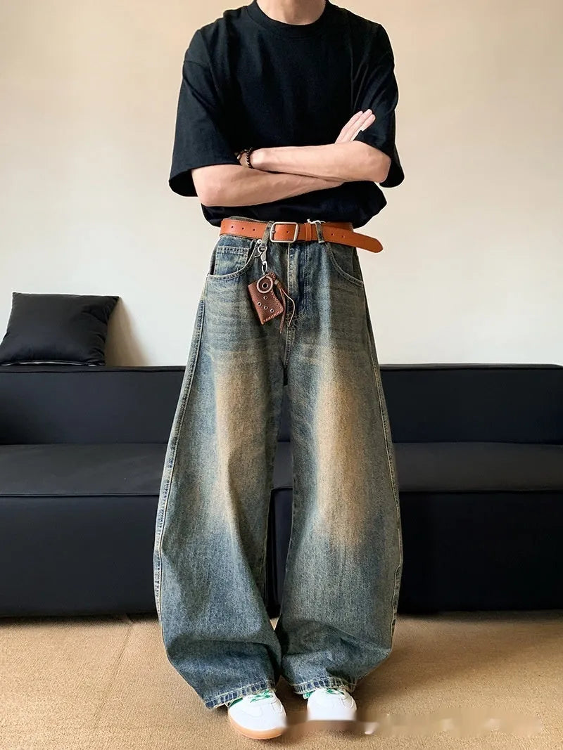Men's retro blue distressed denim pants with a slim wide-leg fit and a zipper fly.