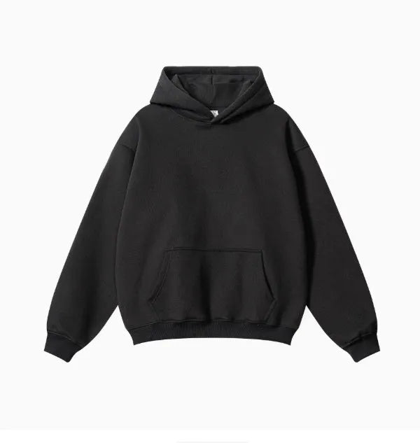 Man wearing a loose-fit grey cotton terry hooded sweater with drop-shoulder sleeves.