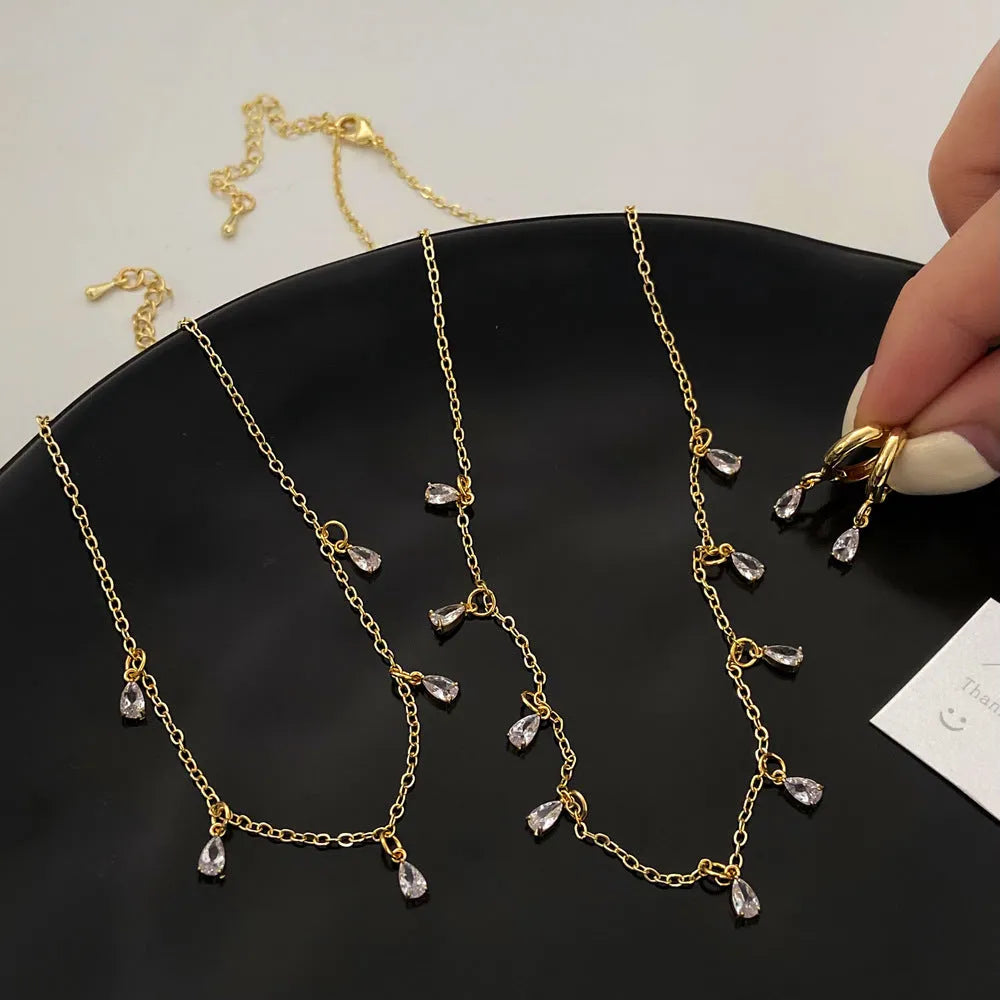 Women's zircon jewellery set showing geometric pendant necklace, matching earrings, and anklet with meteor shower design