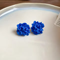 Blue geometric earrings with resin flower detailing and cloth material construction