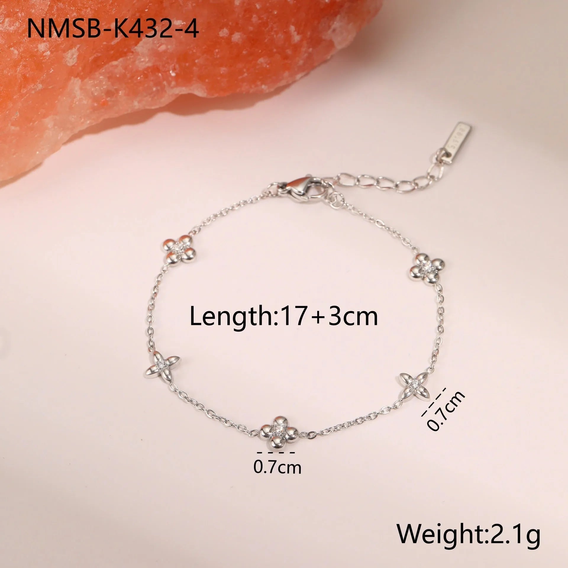 Women's stainless steel bracelet with 18K gold plating and a geometric zircon star pendant on wrist.