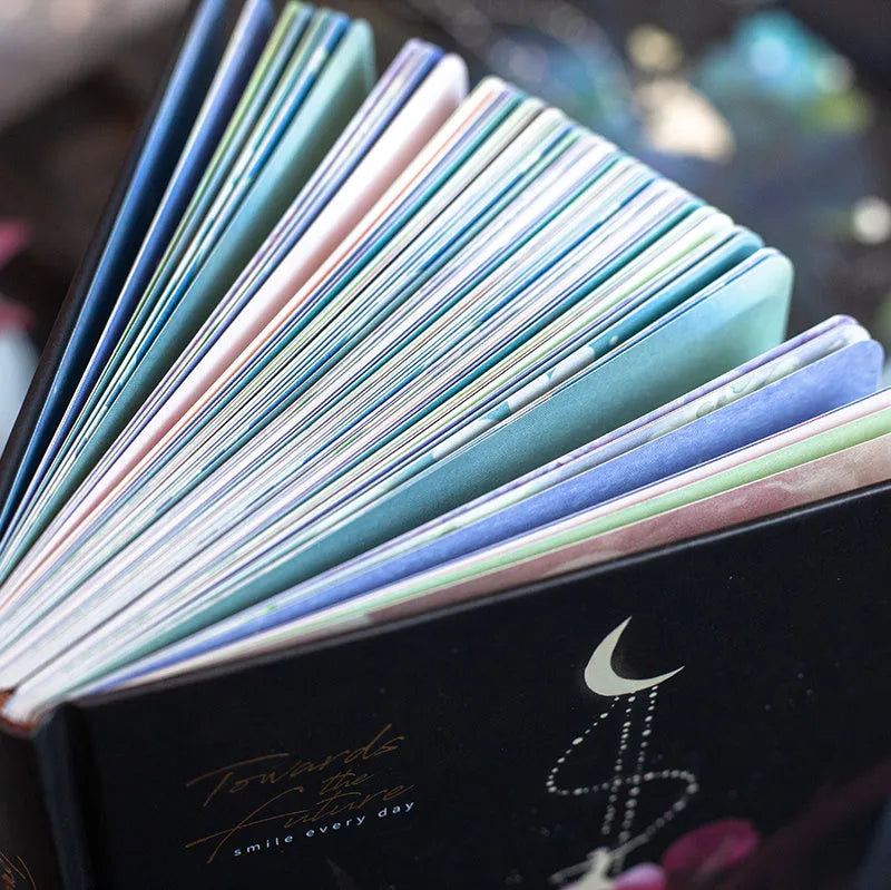 A5 notebook with luminous purple cover open to show pages filled with colour illustrations.
