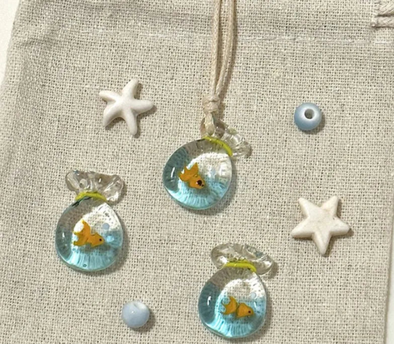 Women's necklace with coloured glaze joker charm on cotton linen chain in small fish lucky bag colour