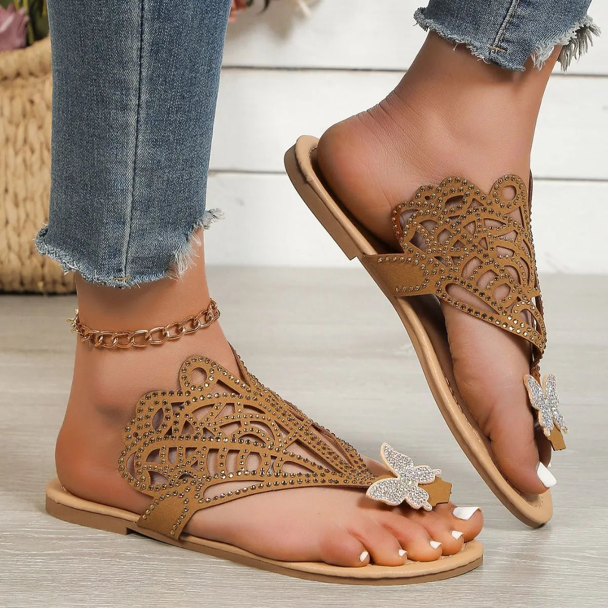Women's black slip-on sandals with rhinestone decorations and a flat rubber sole.
