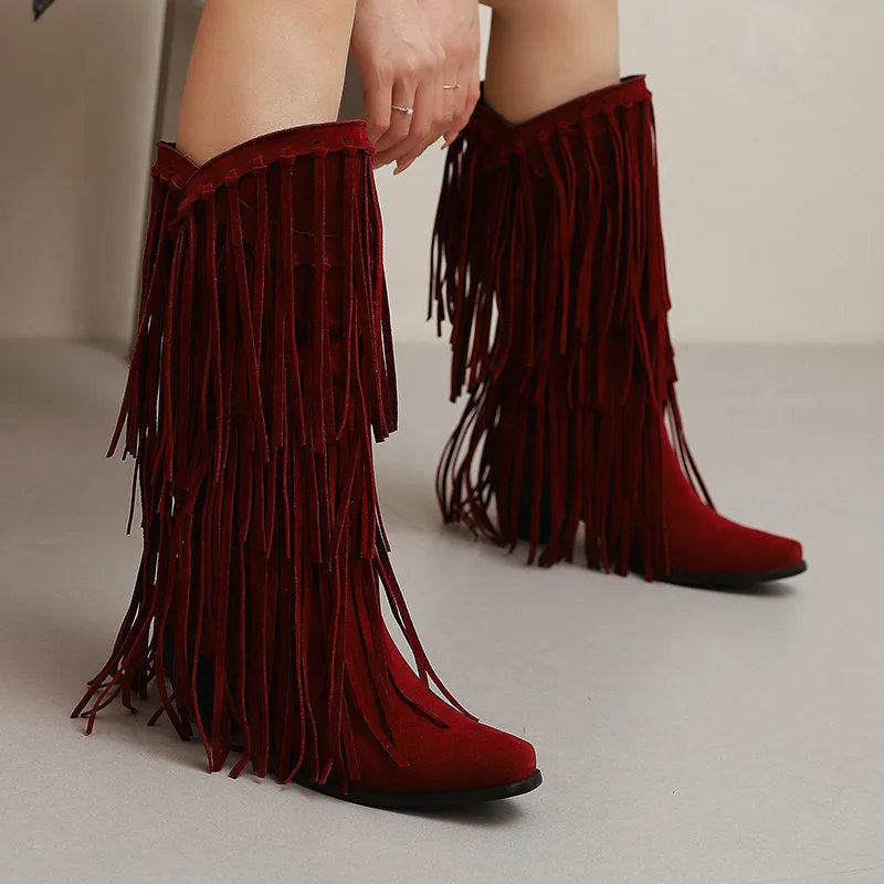 Women's beige suede mid-calf boots with a chunky heel and tassel detail on display.