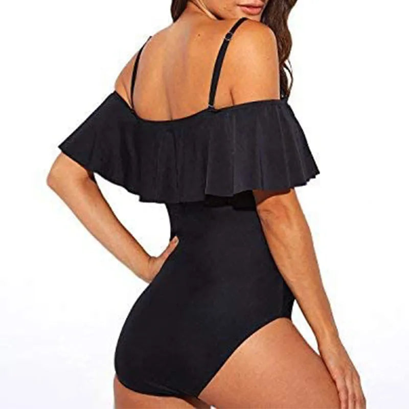 Black one-piece swimsuit with cut-out detail and ruffled straps on a tube top.