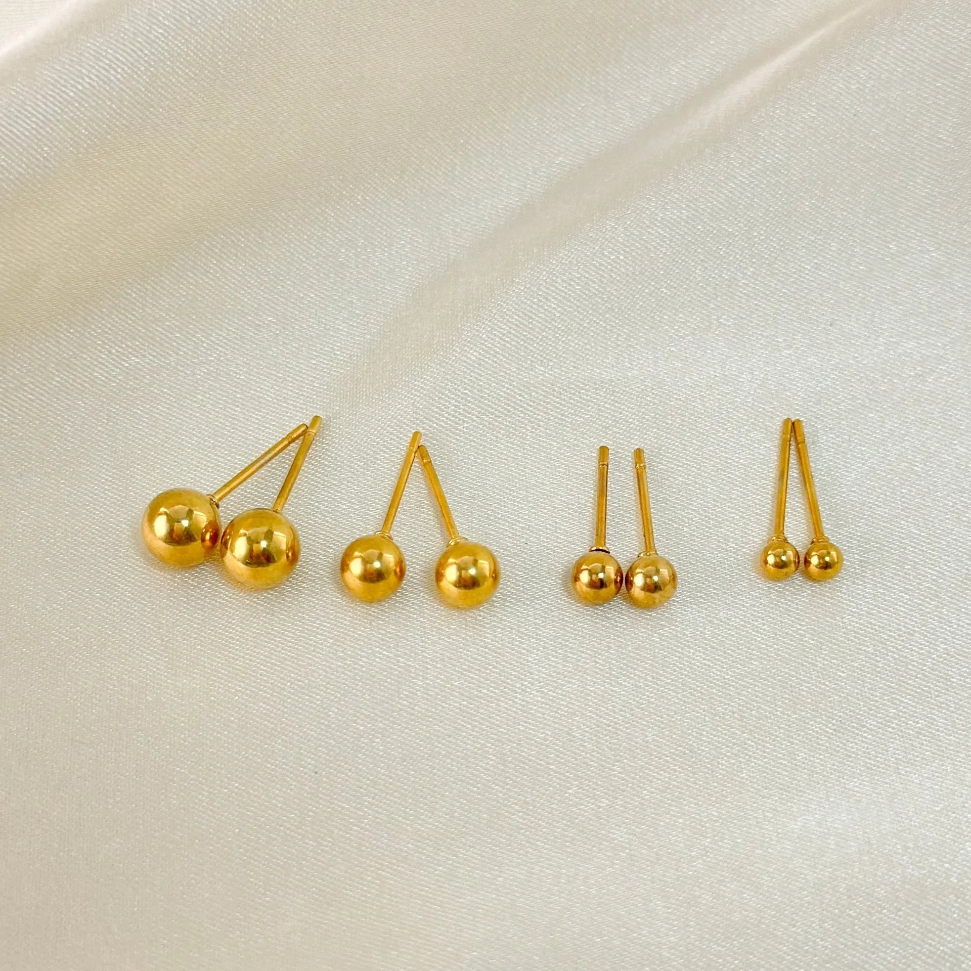 Stainless steel ball stud earrings in gold and silver colours showing 3mm to 6mm size range
