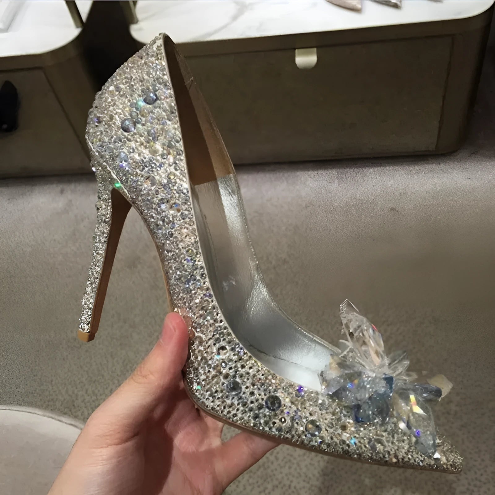 Gold women's high heel with pointed toe, rhinestones, and a stiletto heel on a white background.