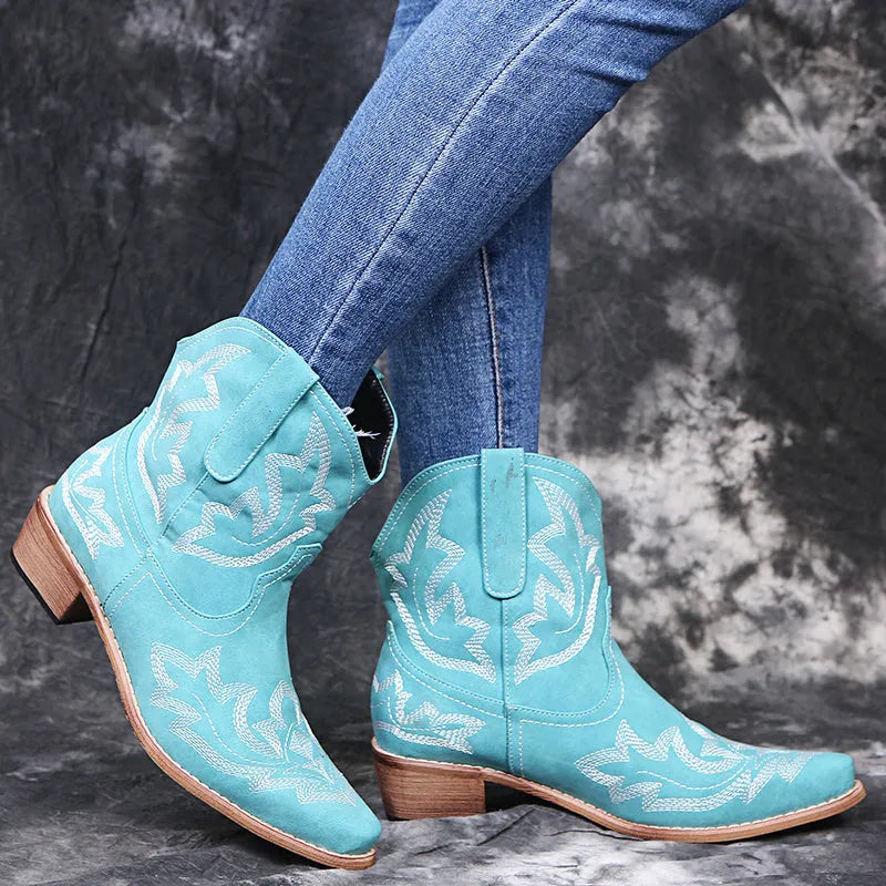 Blue women's cowboy boots with white embroidery, a low wedge heel, and a pointed toe