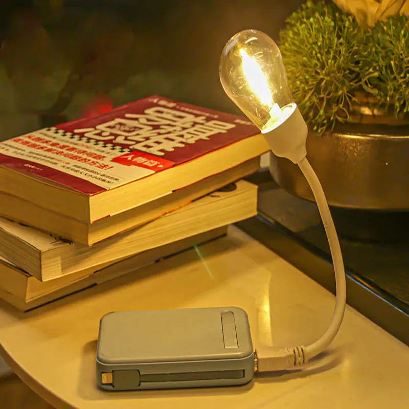A folding USB rechargeable night light with a glowing tungsten filament S14 LED bulb.