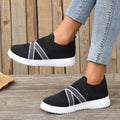 Black women's flyknit mesh casual shoes with a flat rubber sole and a tassel detail on the upper.