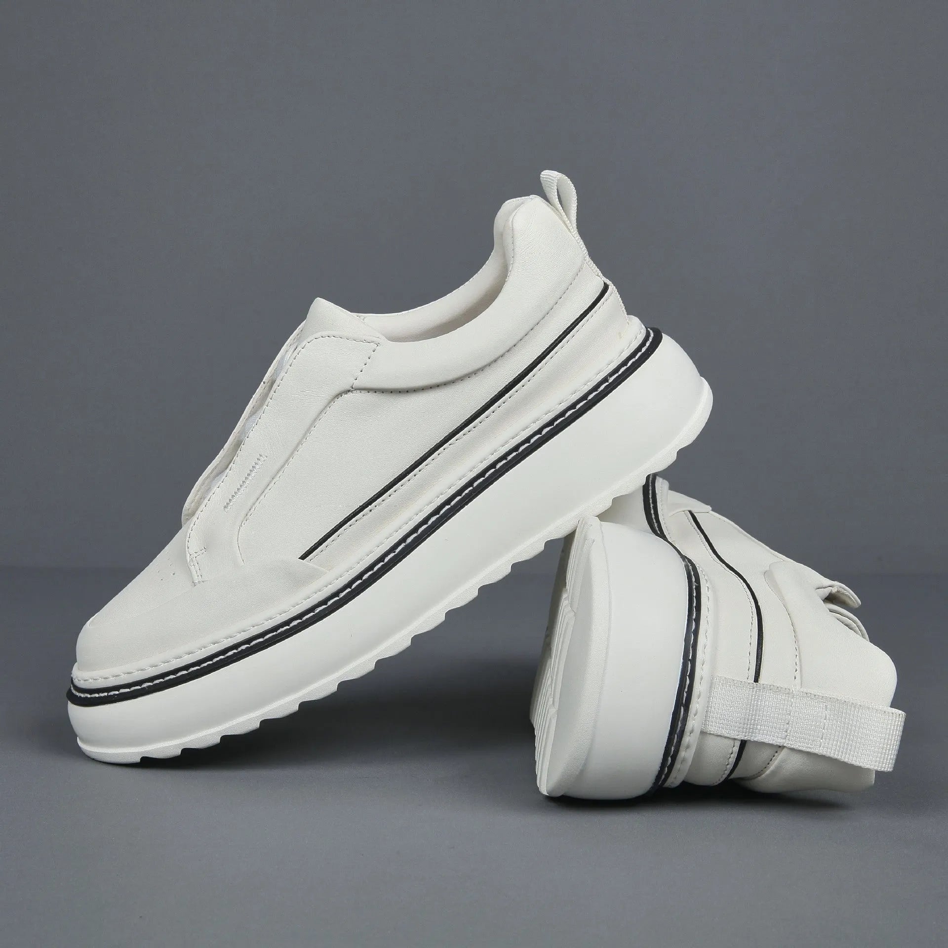 Black leather low-top slip-on sneaker with elastic sides and foam sole on white background