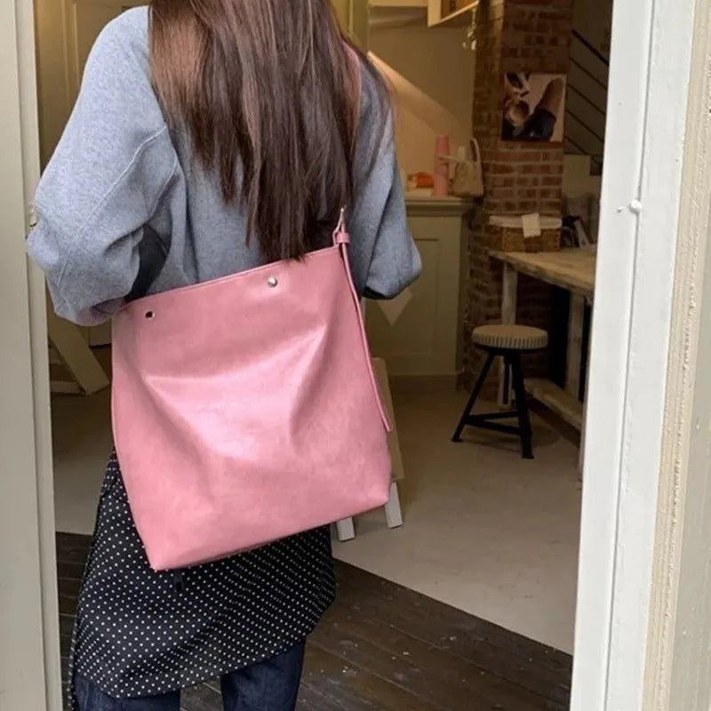 Pink corduroy one-shoulder commuter bag with a single strap and PU lining.