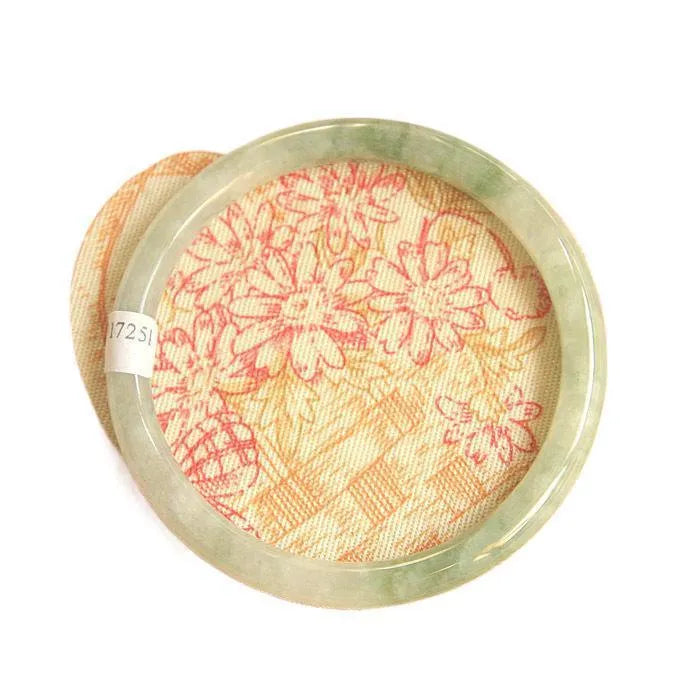 Green jade waxy geometric bracelet with Chinese-style design on a wrist.
