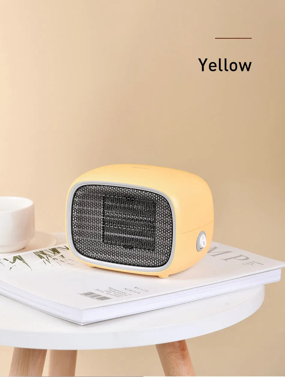 Green, white and yellow mini personal space heater on a desk showing compact size.