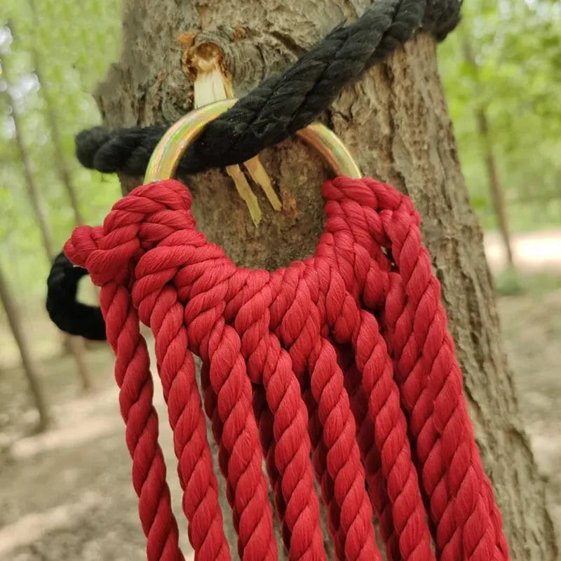 Nylon rope mesh hammock hung between trees showing open weave pattern and included tying ropes