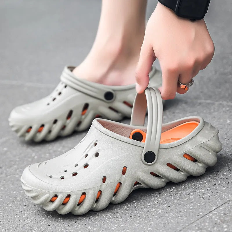 Men's beige EVA slipper sandals with hollow-out design and round toe holder on a plain background.