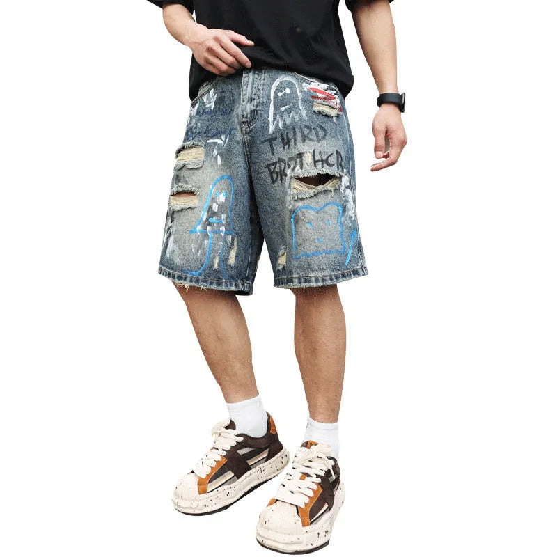 Blue men's ripped denim shorts with graffiti-style detailing and straight-leg cut.