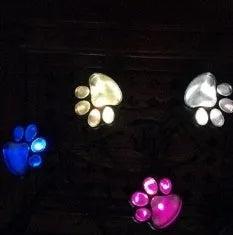 Black bear paw shaped solar garden lights with four paw prints connected to solar panel