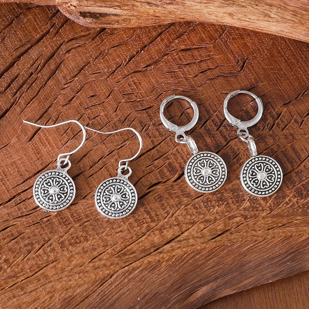 A pair of bohemian retro geometric earrings with a distressed finish and round elements.