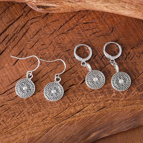 A pair of bohemian retro geometric earrings with a distressed finish and round elements.