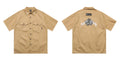 Men's black loose fit cotton blend pocket shirt with half sleeves and embroidered detail on a hanger.
