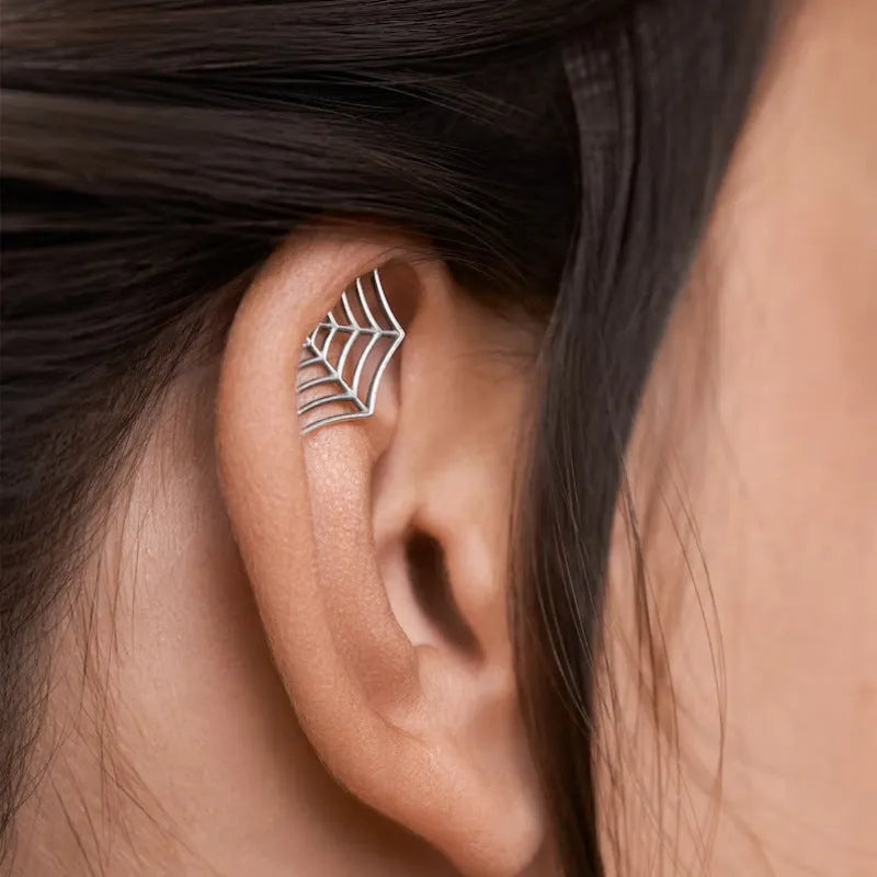 Spider web design metal stud earrings in gold or silver electroplated finish.