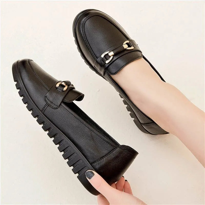 Black leather pumps with soft rubber soles, microfibre upper, and low flat heels on a white background