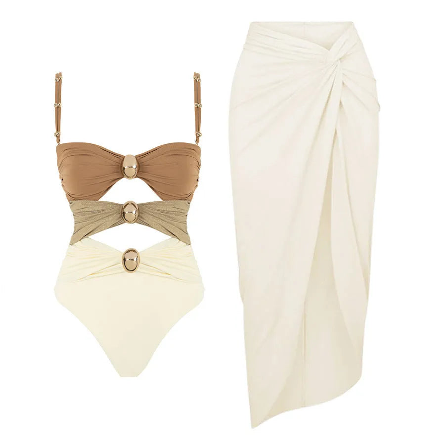 Women's solid colour one-piece swimsuit with matching skirt and gold button detail.