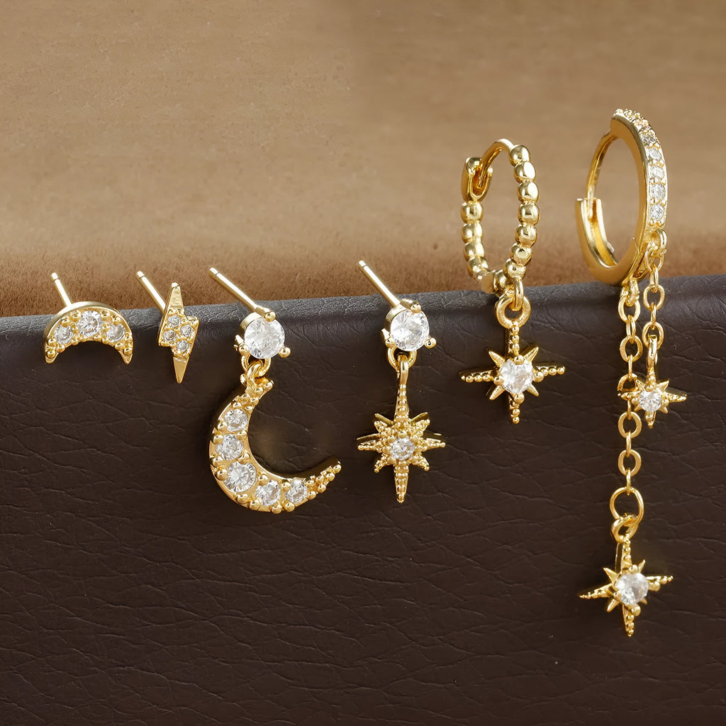 Six pairs of gold electroplated earrings with chain tassel and zircon stud designs representing different months