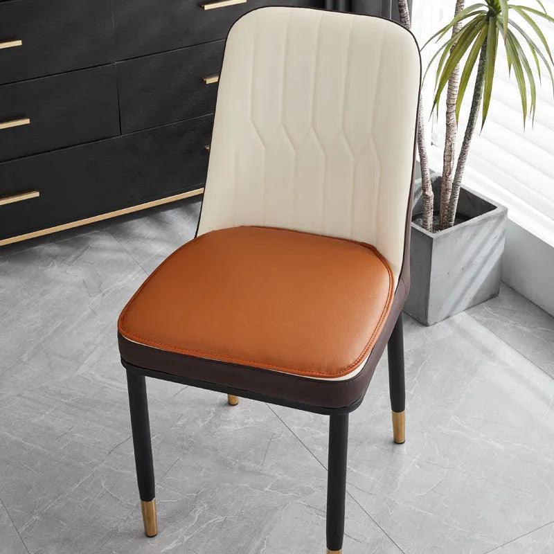 Brown leather horseshoe-shaped seat cushion with non-slip backing on a wooden chair.