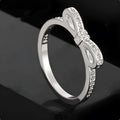 Silver bow-shaped ring with rhinestone zircon crystal detailing showing side profile view