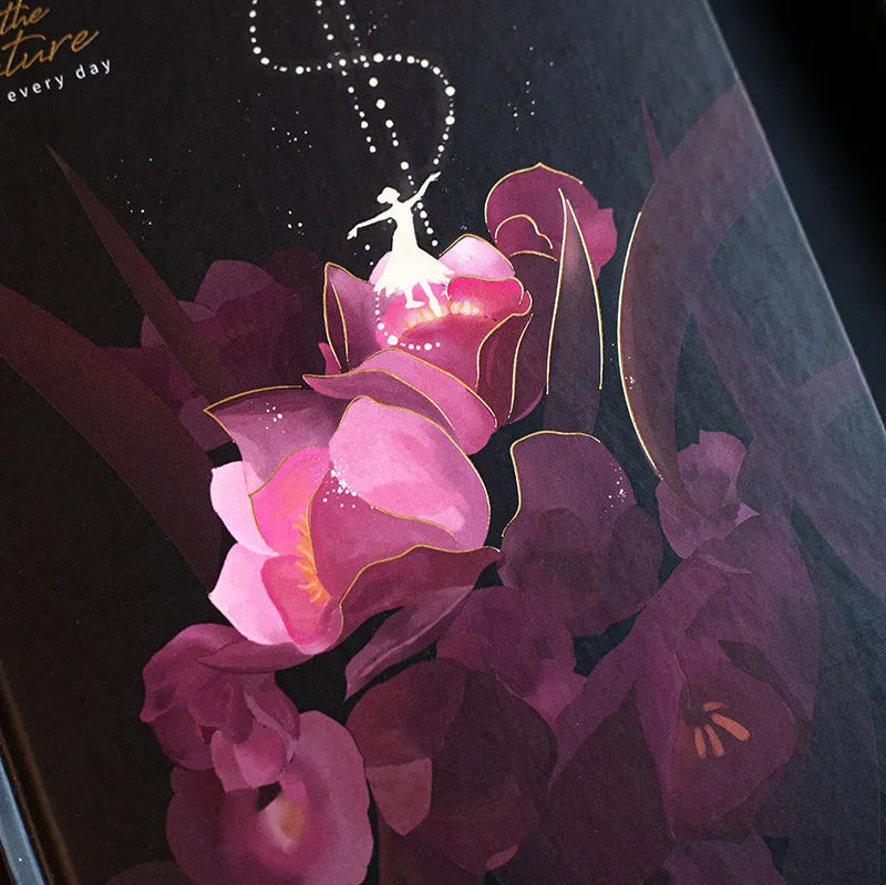 A5 notebook with luminous purple cover open to show pages filled with colour illustrations.