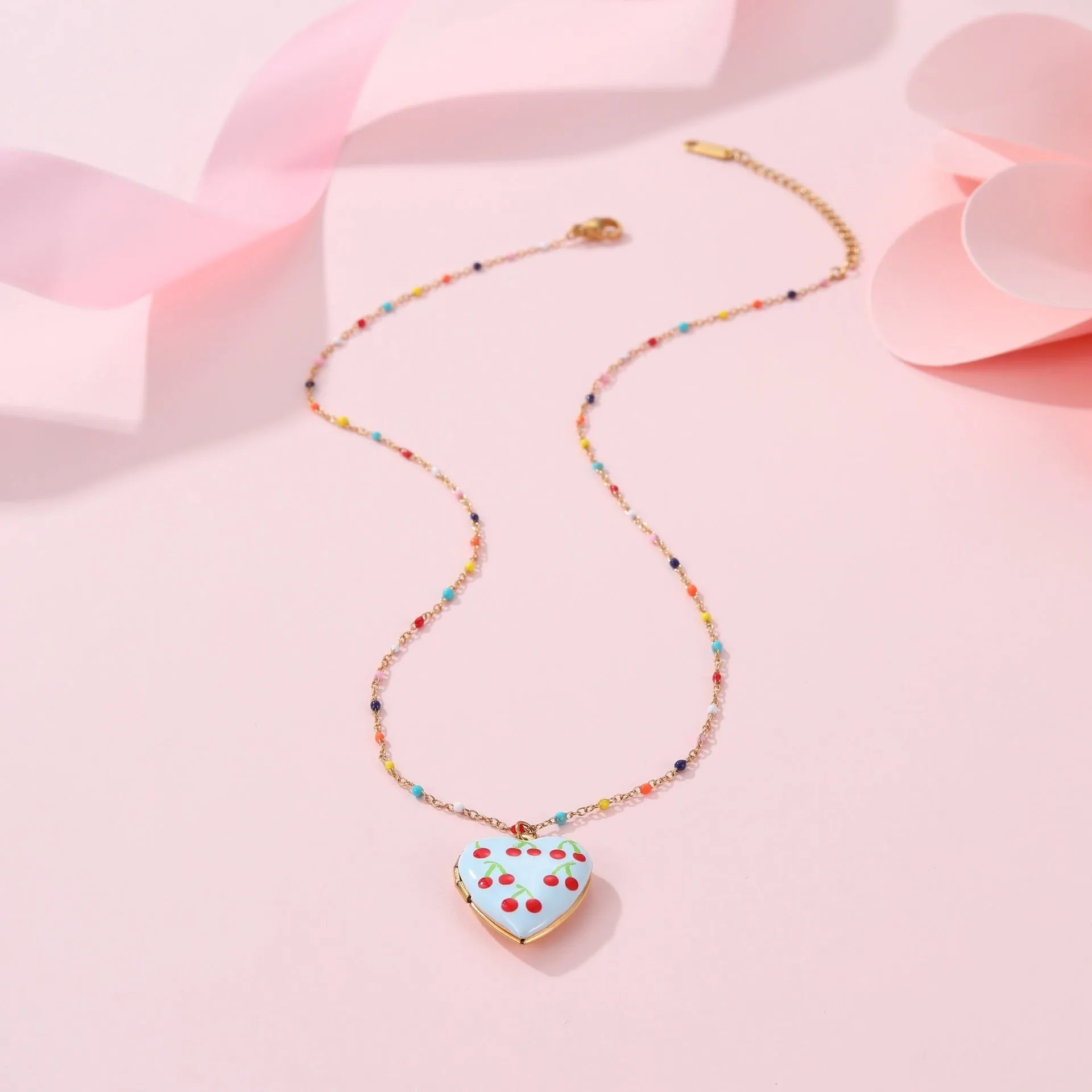 Gold-plated heart-shaped fruit pendant necklace on a stainless steel chain, showing grape design detail.