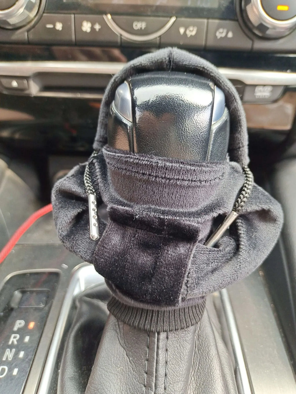 Pure cotton knitted gear lever sweater decoration in assorted colours on a car gear stick.
