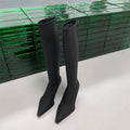 Black pointed toe below the knee stiletto heel boots with a back zipper fastening.