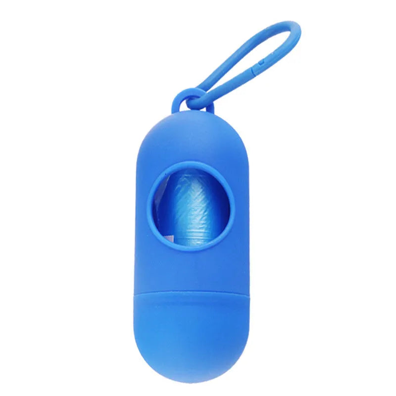Compact black dog waste bag dispenser with a metal hook and Velcro strap, shown attached to a dog lead.