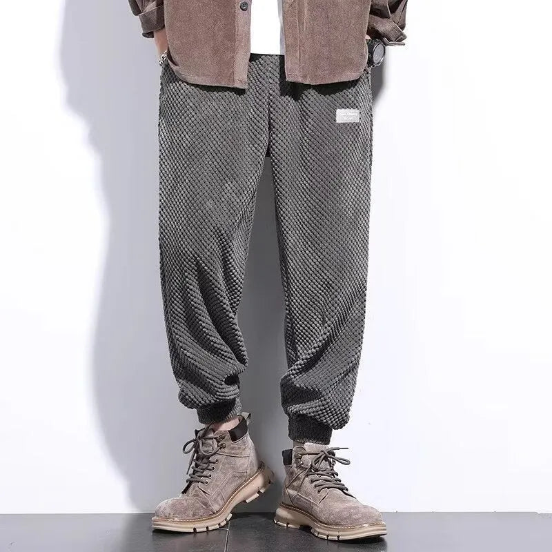 Men's grey ankle-tied straight leg sweatpants with elastic waist on a white background.