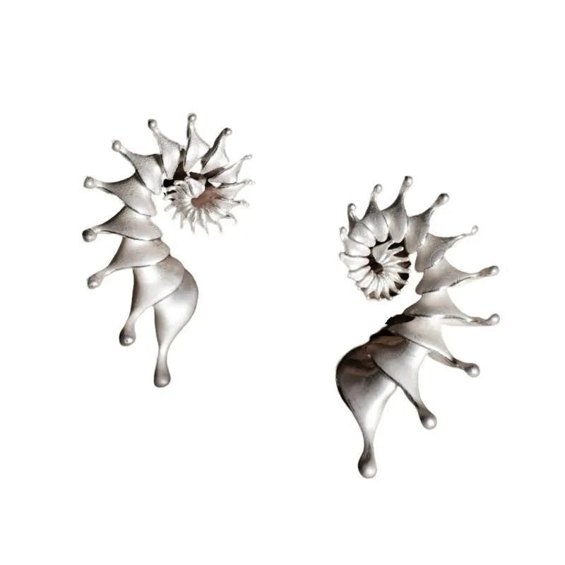 A pair of matte finish conch stud earrings with an exaggerated three-dimensional and irregular design.