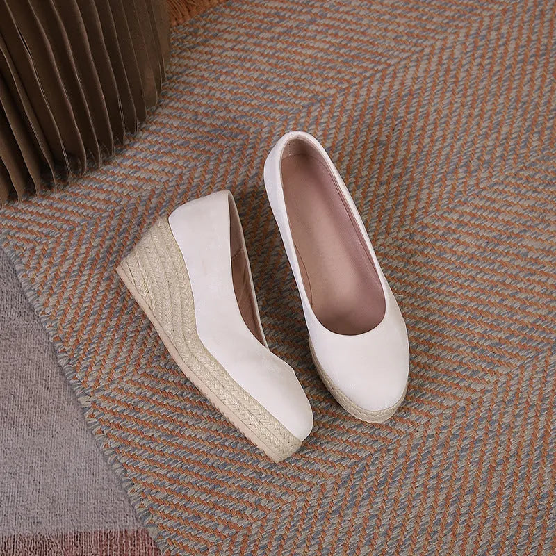 Women's apricot wedge heel pumps with rope-textured sole and shallow V-cut opening on a white background.