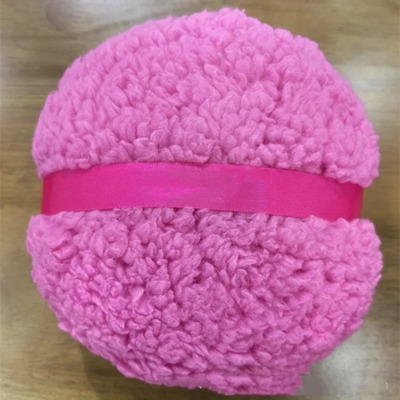 Oversized soft plush makeup powder puff in pink, white, and skin colour on a white background