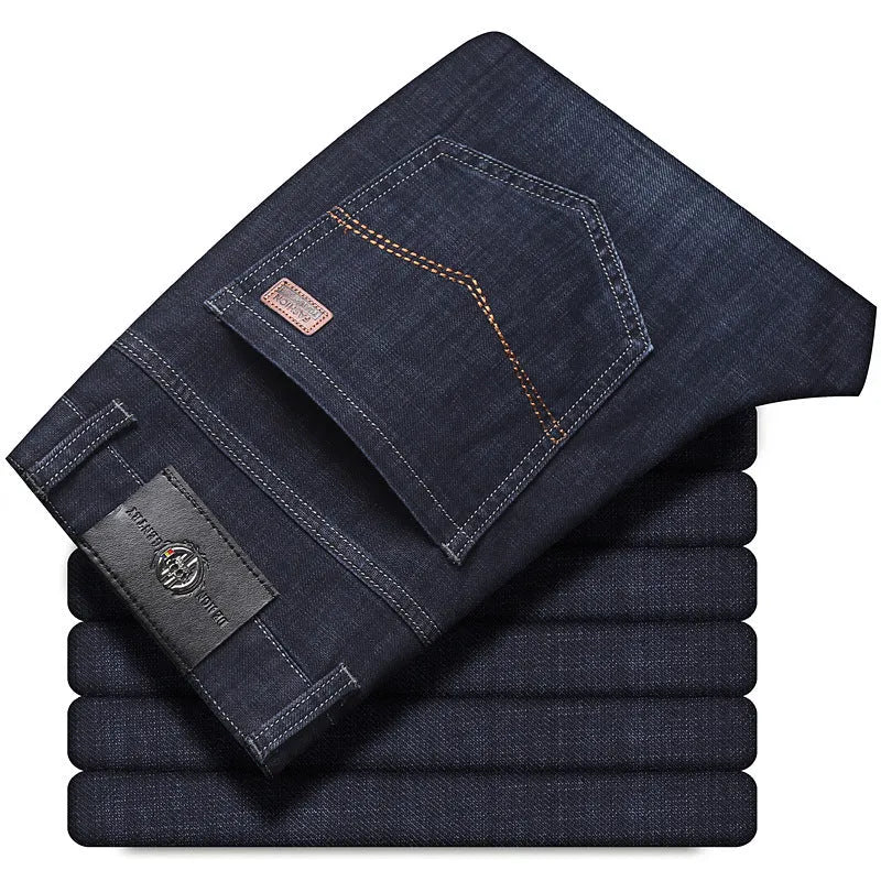 Man wearing black loose fit straight leg stretch denim jeans, showing mid waist and zip fly.