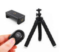Black flexible octopus tripod with bent legs wrapped around a pole, holding a smartphone.